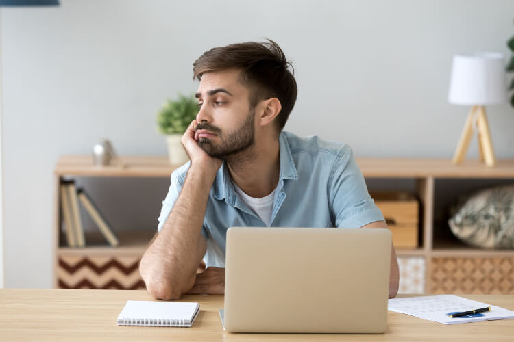 Tired man distracted from computer work and procrastinate